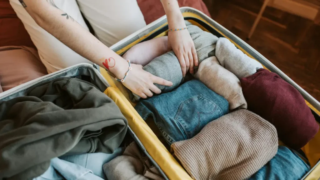 a person packing a 80 linear inches luggage